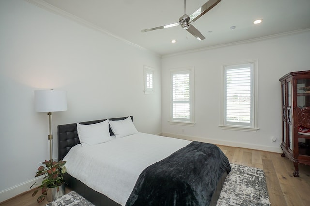 bedroom with hardwood / wood-style flooring, ceiling fan, and crown molding