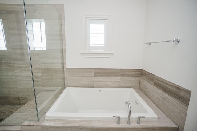 bathroom featuring a wealth of natural light and plus walk in shower