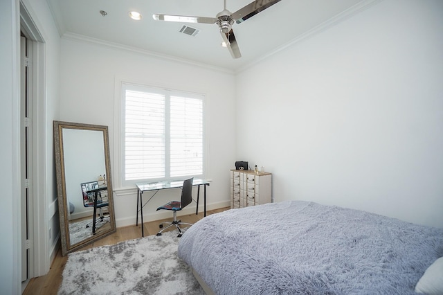 bedroom featuring ceiling fan, wood-type flooring, and ornamental molding