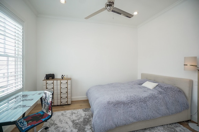 bedroom with ceiling fan, ornamental molding, light hardwood / wood-style flooring, and multiple windows