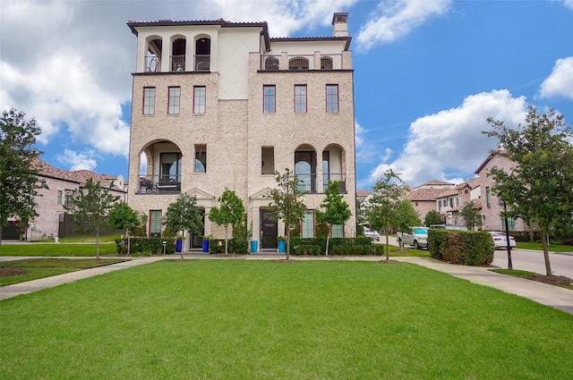 mediterranean / spanish-style house with a balcony and a front lawn