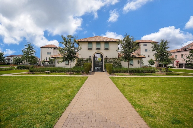 mediterranean / spanish home with a front lawn