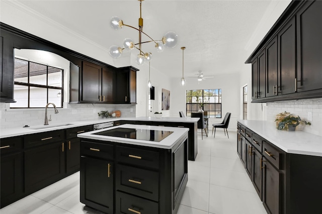 kitchen featuring backsplash, ceiling fan with notable chandelier, black electric cooktop, sink, and decorative light fixtures