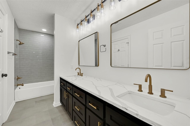 bathroom featuring vanity, a textured ceiling, and tiled shower / bath combo