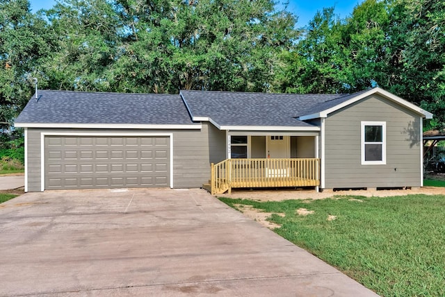 ranch-style home with covered porch, a garage, and a front yard