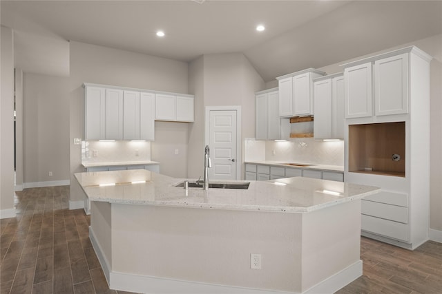 kitchen with white cabinetry, sink, dark hardwood / wood-style flooring, a large island with sink, and lofted ceiling