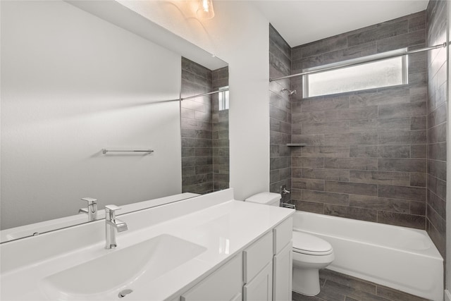 full bathroom featuring hardwood / wood-style flooring, vanity, toilet, and tiled shower / bath