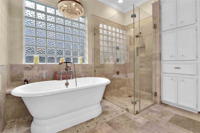 bathroom featuring ornamental molding, a wealth of natural light, independent shower and bath, and tile walls