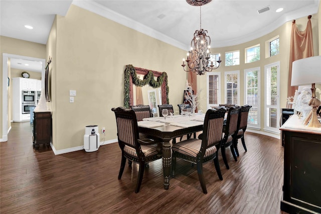 dining room featuring dark hardwood / wood-style flooring, crown molding, and a notable chandelier