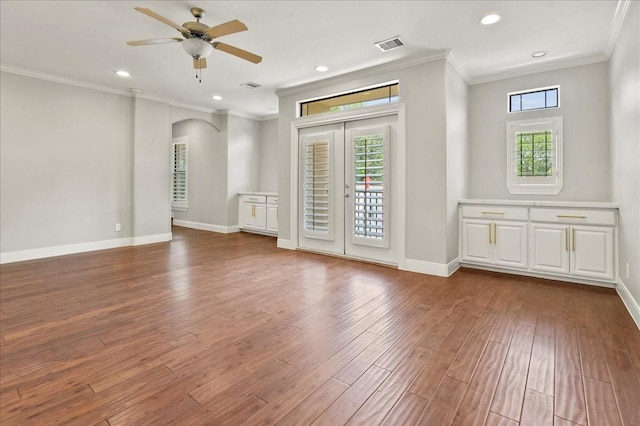 spare room with ceiling fan, ornamental molding, a healthy amount of sunlight, and wood-type flooring