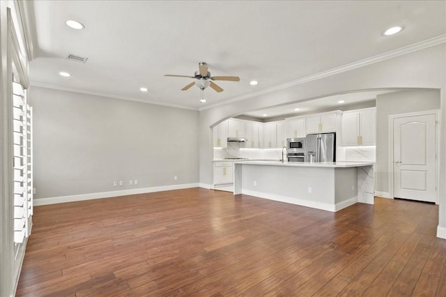 unfurnished living room featuring ceiling fan, ornamental molding, and dark wood-type flooring