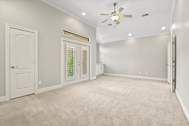 empty room with ceiling fan, light colored carpet, ornamental molding, and french doors