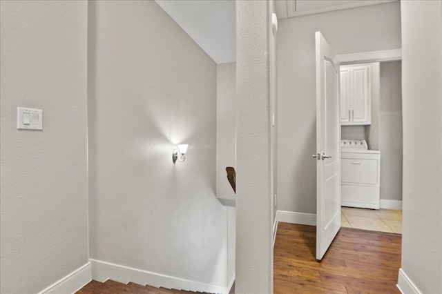 hallway with wood-type flooring, washer / clothes dryer, and vaulted ceiling