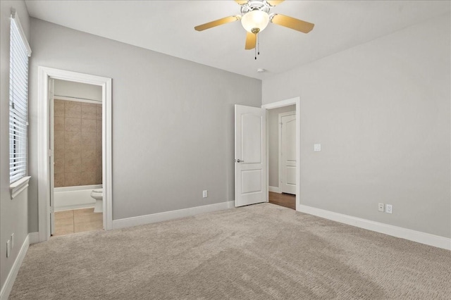 unfurnished bedroom with light carpet, ensuite bath, and ceiling fan