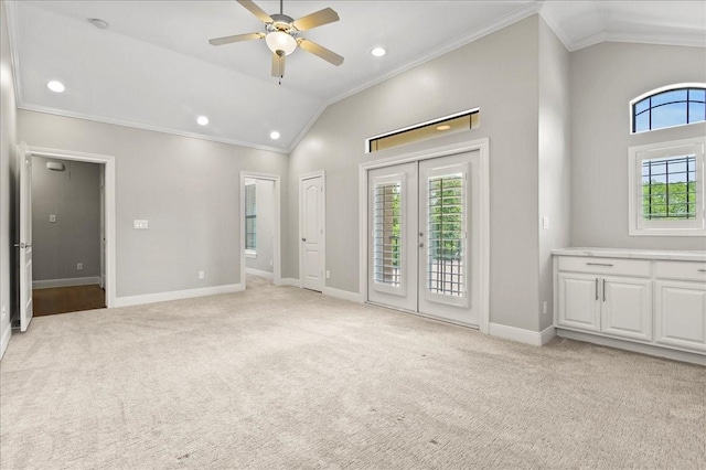 interior space featuring light carpet, ceiling fan, a healthy amount of sunlight, and ornamental molding