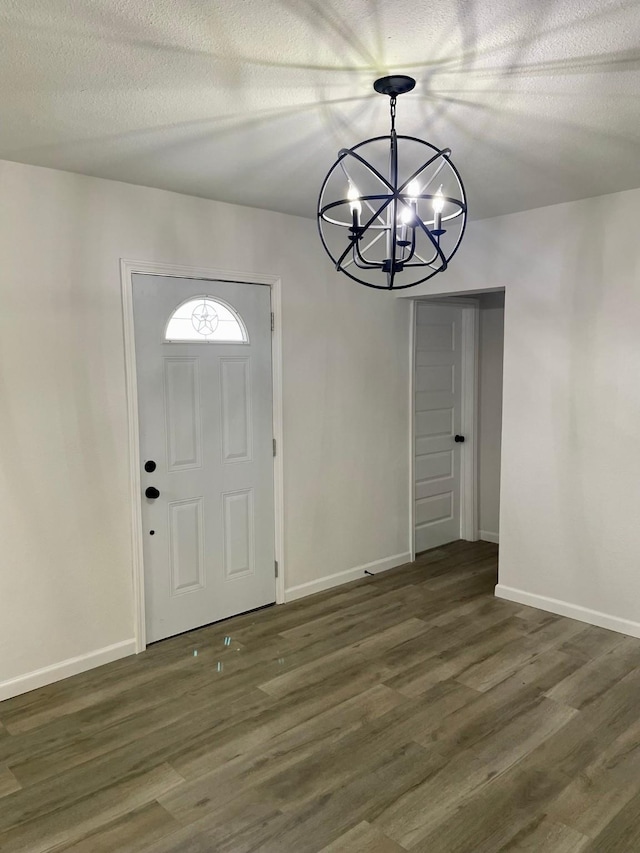 entryway with a chandelier, a textured ceiling, and dark hardwood / wood-style floors