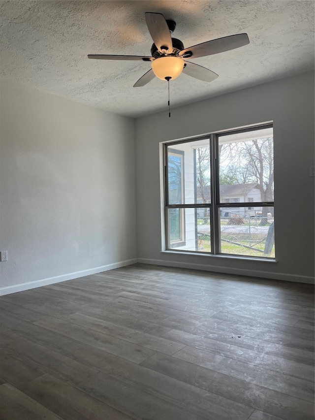 empty room featuring ceiling fan, dark hardwood / wood-style flooring, and a textured ceiling