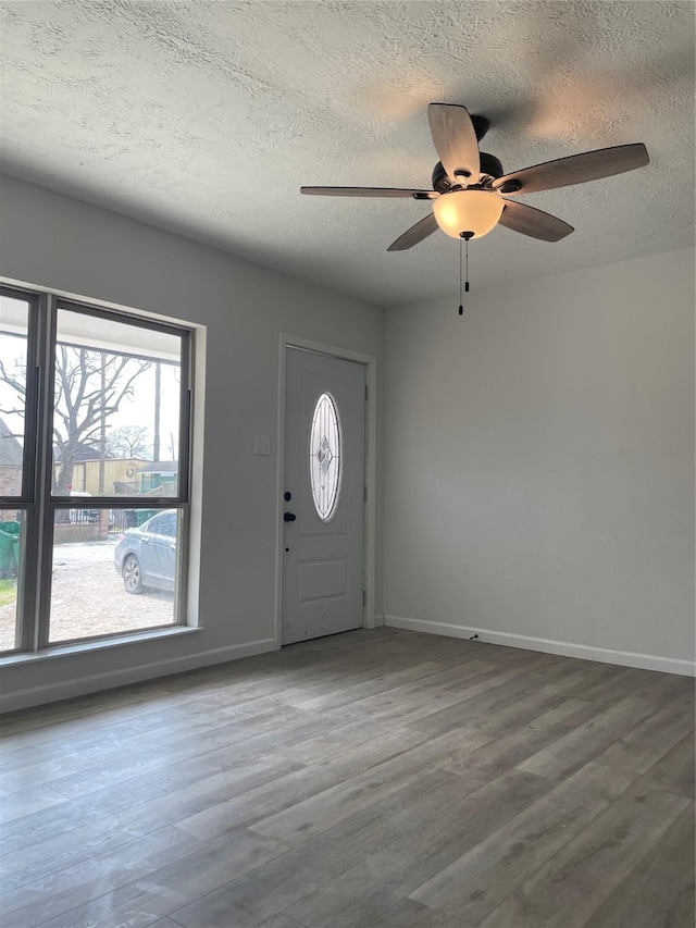 foyer entrance featuring ceiling fan, wood-type flooring, and a textured ceiling