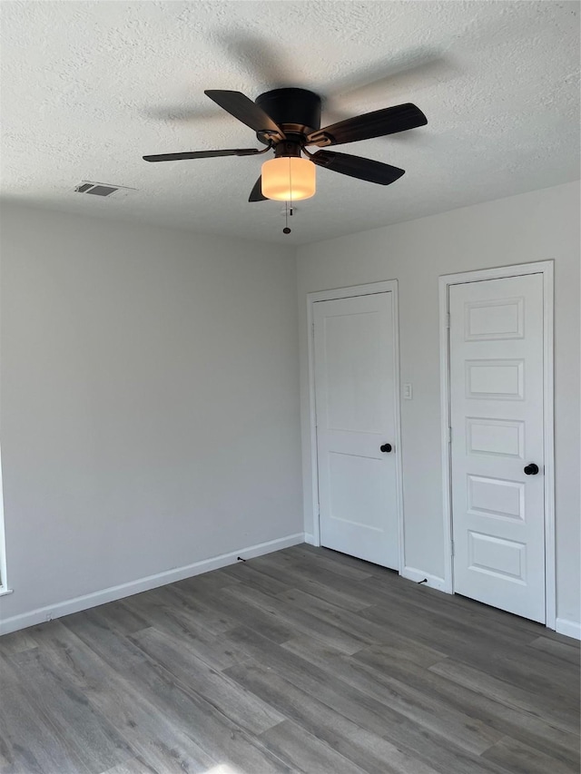 unfurnished bedroom with ceiling fan, wood-type flooring, and a textured ceiling