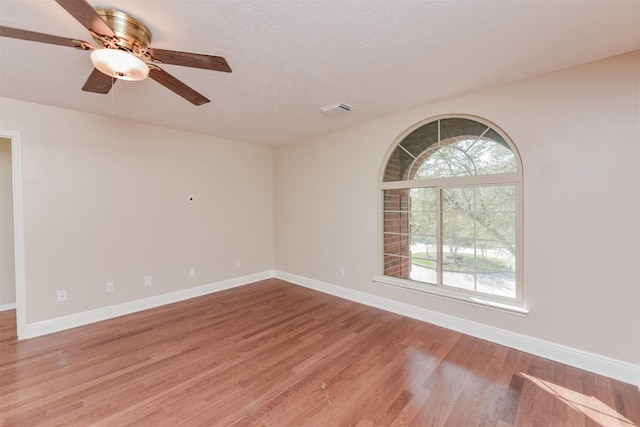 unfurnished room with a textured ceiling, hardwood / wood-style flooring, and ceiling fan