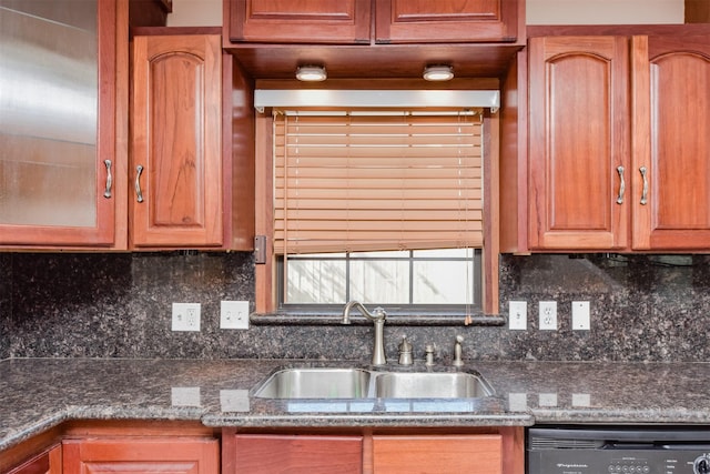 kitchen featuring black dishwasher, tasteful backsplash, dark stone counters, and sink