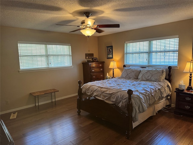 bedroom featuring ceiling fan, dark hardwood / wood-style flooring, and a textured ceiling