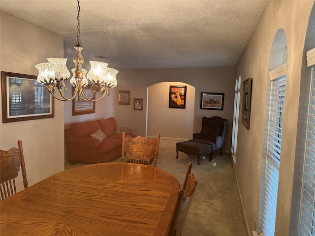 carpeted dining space featuring a textured ceiling and a notable chandelier