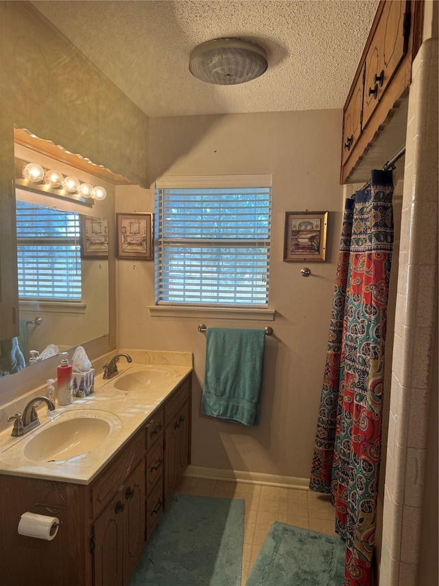 bathroom featuring tile patterned floors, vanity, and a textured ceiling