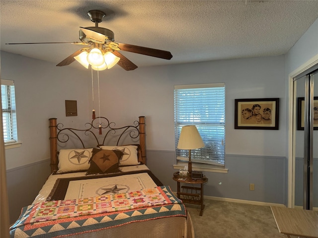 carpeted bedroom featuring ceiling fan, a textured ceiling, and a closet