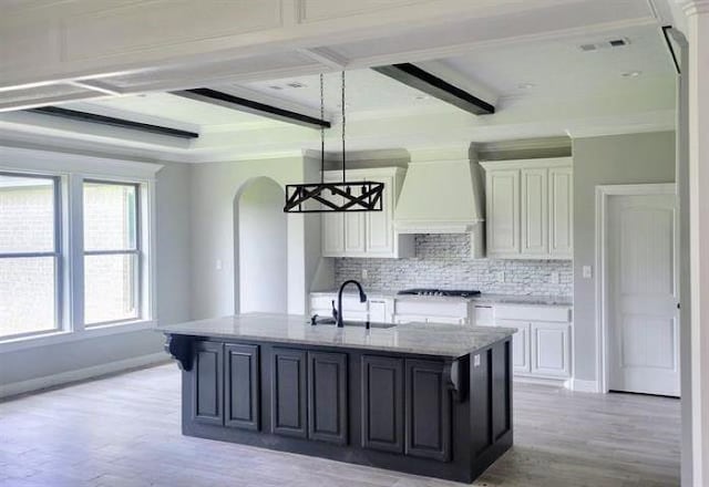 3090 Ethan Symone St, Beaumont, TX 77705 - kitchen with custom range hood, white cabinetry, a kitchen island with sink, and sink