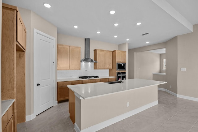 kitchen with backsplash, wall chimney exhaust hood, an island with sink, and built in microwave