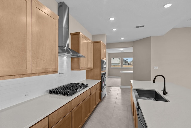 kitchen featuring decorative backsplash, stainless steel appliances, sink, wall chimney range hood, and light tile patterned floors