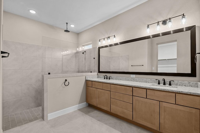 bathroom with tile patterned floors, vanity, and a tile shower