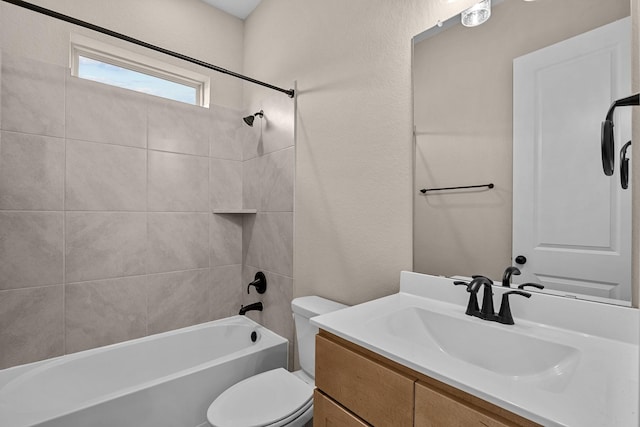 full bathroom featuring vanity, tiled shower / bath combo, and toilet