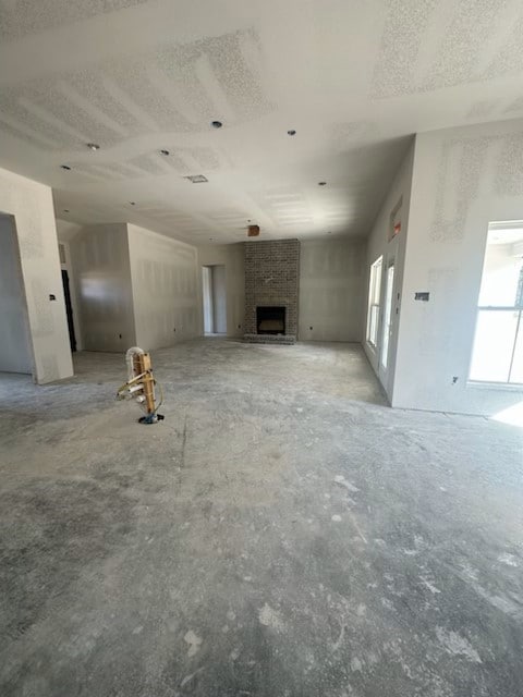 unfurnished living room with a brick fireplace