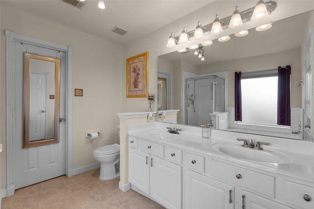 bathroom featuring toilet, vanity, tile patterned floors, and a shower with door