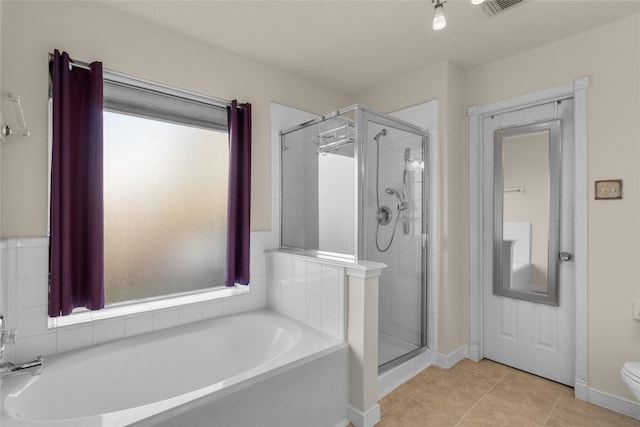 bathroom featuring tile patterned floors, toilet, and plus walk in shower