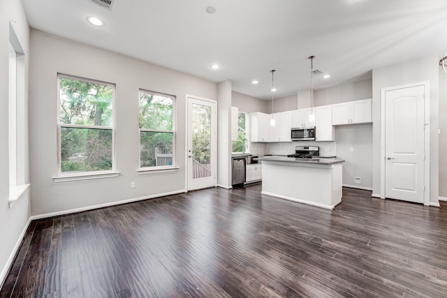 kitchen with white cabinetry, a center island, hanging light fixtures, dark hardwood / wood-style floors, and appliances with stainless steel finishes