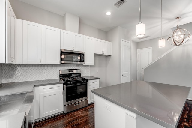 kitchen with tasteful backsplash, stainless steel appliances, dark wood-type flooring, decorative light fixtures, and white cabinetry