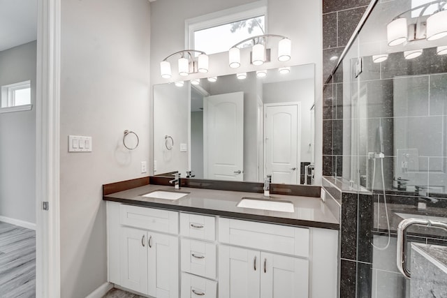 bathroom with vanity, hardwood / wood-style flooring, a shower with door, and a healthy amount of sunlight