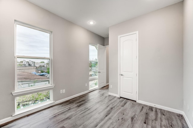 empty room featuring a healthy amount of sunlight and light hardwood / wood-style floors