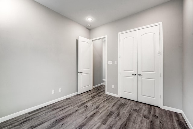 unfurnished bedroom featuring dark wood-type flooring and a closet