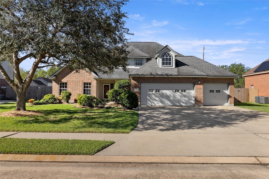 view of front of property featuring central AC unit, a garage, and a front lawn