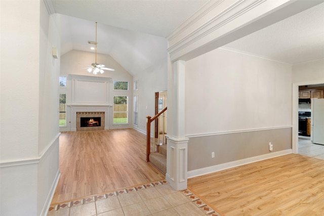 unfurnished living room featuring ceiling fan, light hardwood / wood-style floors, crown molding, and a tile fireplace