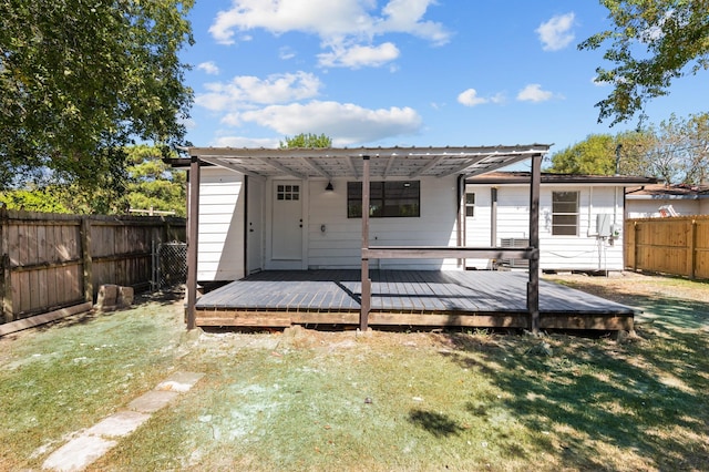 rear view of property featuring a lawn and a deck