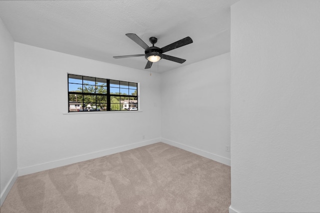 carpeted spare room with a textured ceiling and ceiling fan