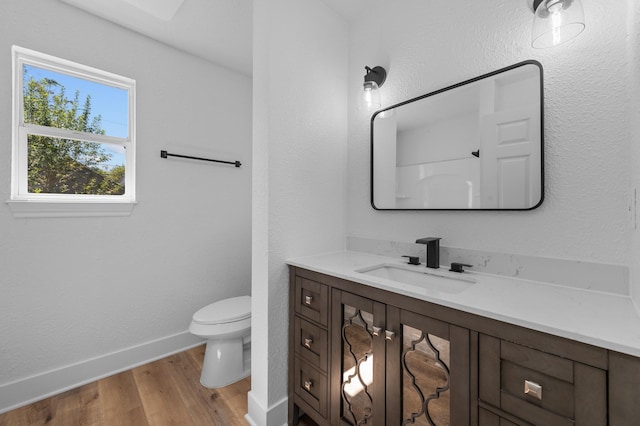 bathroom featuring vanity, hardwood / wood-style flooring, and toilet