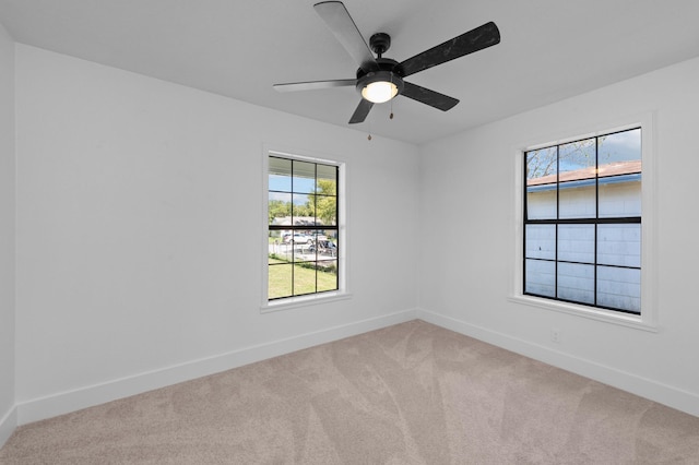 carpeted spare room featuring ceiling fan