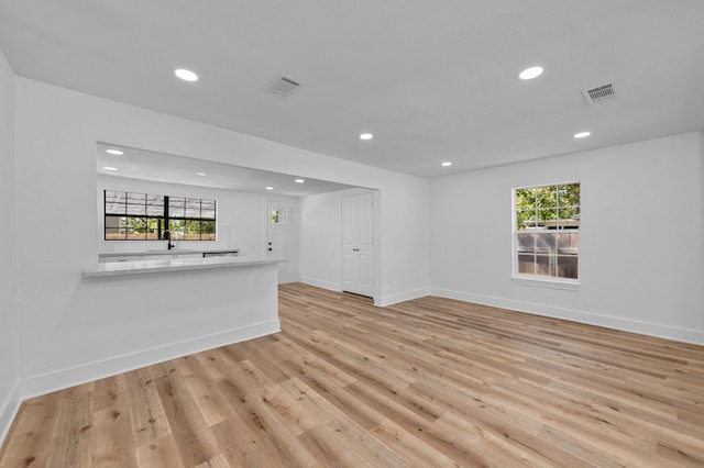 unfurnished living room with a wealth of natural light and light hardwood / wood-style flooring