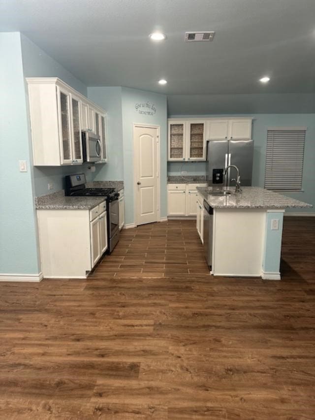 kitchen featuring sink, stainless steel appliances, dark hardwood / wood-style flooring, a center island with sink, and white cabinets